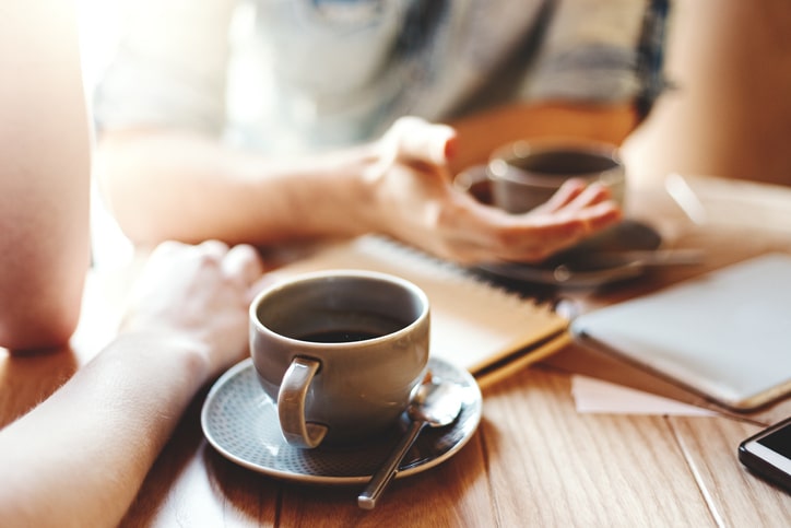 Two people having a discussion about finances over coffee